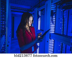 Caucasian businesswoman using digital tablet in server room