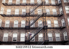 Caucasian couple standing on apartment fire escape