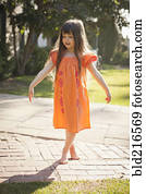 Caucasian girl playing barefoot in backyard