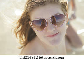 caucasiano, menina adolescente, desgastar, óculos sol coração-formou