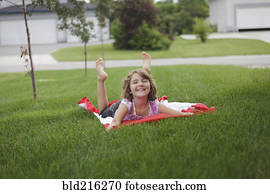 caucasiano, menina, deitando, ligado, gramado, em, suburbano, vizinhança