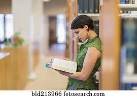 Mixed race student reading book in library