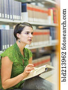 Mixed race student reading book in library
