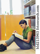 Mixed race student reading book in library