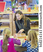 Montessori teacher helping students in classroom