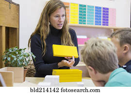 Montessori teacher helping students in classroom