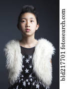 Serious Asian girl wearing furry vest