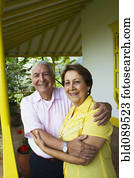 Senior Hispanic couple hugging on porch Senior Hispanic couple hugging on porch