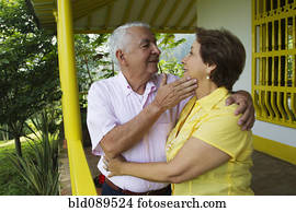 Senior Hispanic couple hugging on porch Senior Hispanic couple hugging on porch