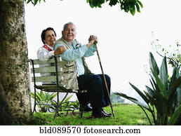 Senior Hispanic couple sitting on park bench Senior Hispanic couple sitting on park bench