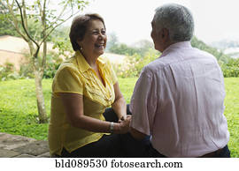 Senior Hispanic couple sitting outdoors together Senior Hispanic couple sitting outdoors together