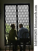 Senior Hispanic couple sitting together near window Senior Hispanic couple sitting together near window