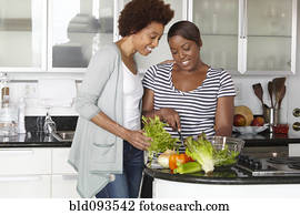 African American mother and daughter preparing salad