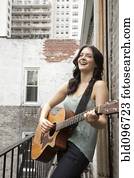 Woman playing guitar on fire escape