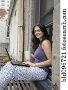 Woman using laptop on fire escape