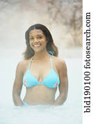 African woman standing in hot tub