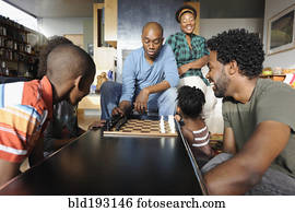 Black family watching chess game