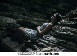 Caucasian woman laying on rock formation