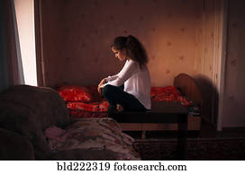 Caucasian woman sitting in bedroom