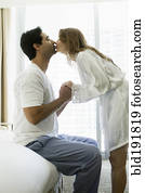 Hispanic couple kissing in bedroom