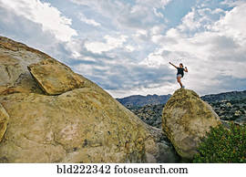 Mixed race woman climbing rock formation