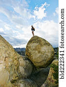 Mixed race woman climbing rock formation