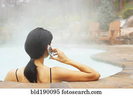 Woman talking on cell phone in hot tub