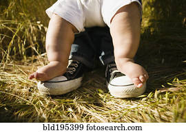 Baby's feet on top of father's feet