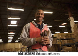 Black man in reflector-vest in warehouse