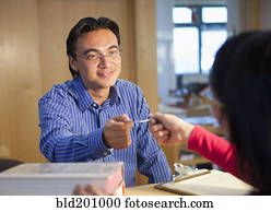 Hispanic man checking out books with library card