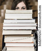 Mixed race student holding stack of books Mixed race student holding stack of books