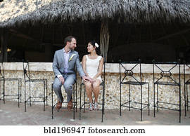 Newlywed couple sitting on bar stools