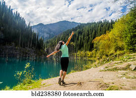 Carefree Caucasian woman walking near lake 