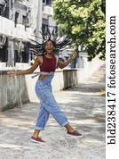 Carefree Mixed Race woman twirling hair outdoors