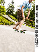 Caucasian boy skateboarding barefoot