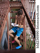 Caucasian man sitting on urban fire escape writing in journal