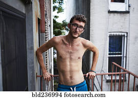 Caucasian man standing on urban fire escape