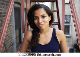 Portrait of smiling woman sitting on urban fire escape