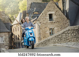 Carefree Caucasian couple riding blue motor scooter