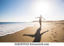 Carefree Caucasian woman walking on beach