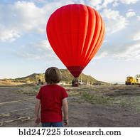 Caucasian boy watching distant hot air balloon