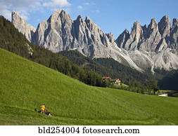 Distant man cutting grass on hill