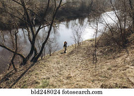 Distant woman standing near river