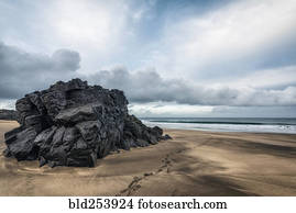 Footprints on beach near rock formation