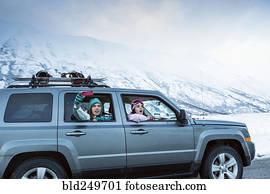 Friends photographing from car in winter