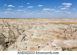 Layered rock formations under blue sky, Badlands National Park, South Dakota, United States