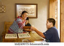 Mother and sons admiring baby turkey at table