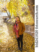 Smiling Asian woman smelling fresh air in autumn