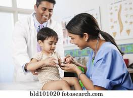 Doctor and nurse examining baby in doctor's office