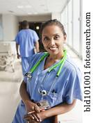 Smiling nurse leaning on window sill in hospital